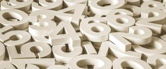 A scattered pile of large white 3D numbers overlapping one another.