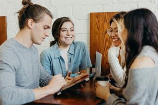 A group of friends at a coffee shop by Brooke Cagle courtesy of Unsplash.