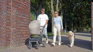 a man and a woman walking a dog and a stroller by Frederik Rosar courtesy of Unsplash.
