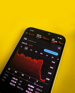 a cell phone with a chart on the screen by Hakan Nural courtesy of Unsplash.