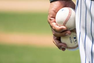 man holding two white baseballs by Jose Francisco Morales courtesy of Unsplash.