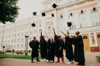 people in black academic dress standing on green grass field during daytime by RUT MIIT courtesy of Unsplash.