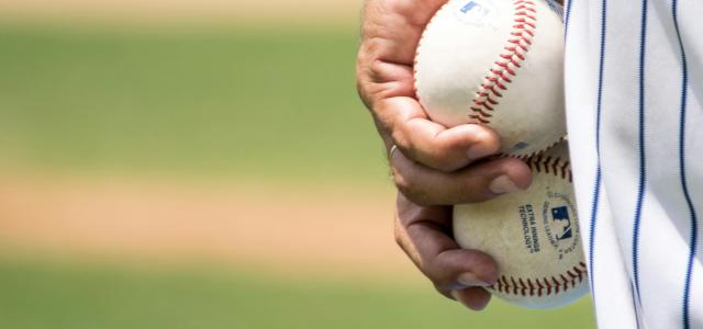 man holding two white baseballs by Jose Francisco Morales courtesy of Unsplash.